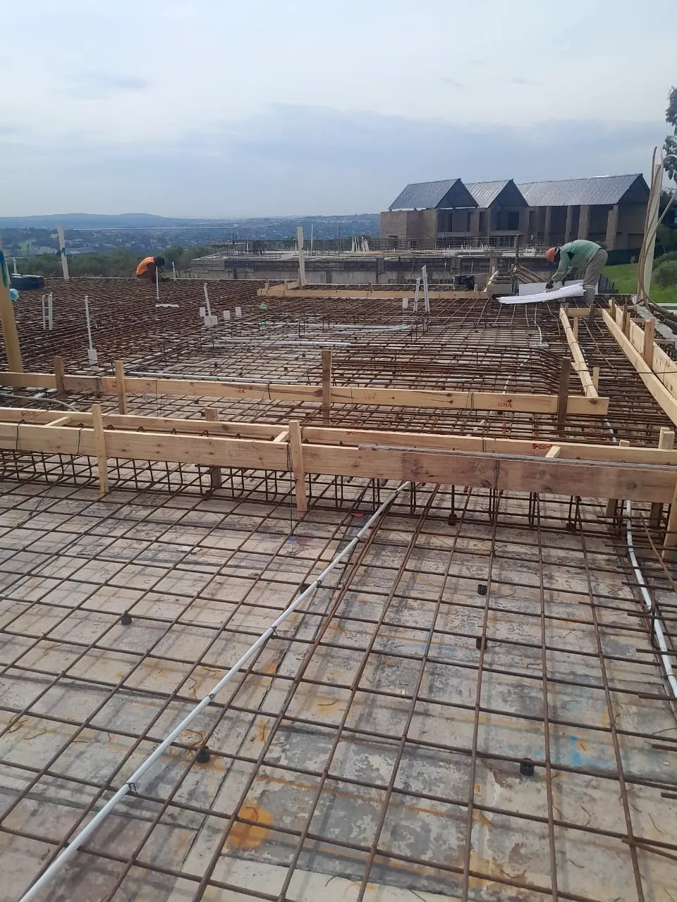 Steel reinforcement grid laid out across a concrete slab before casting